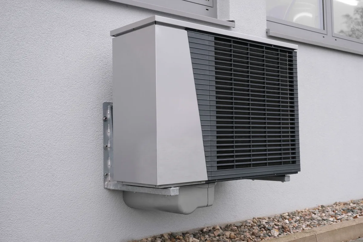 A compact air source heat pump mounted on an outside wall